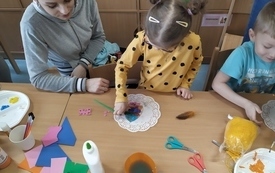 Lena i Szymon z pomocą mam wykonują ozdobę wielkanocną.