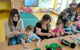 Rodzice i dzieci robią kwiaty.