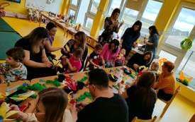 Dzieci i rodzice robią wielkanocne palemki.