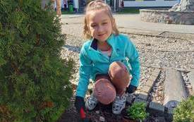 Lena sadzi rośliny w szkolnym ogrodzie