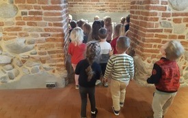 Przedszkolaki podziwiają najstarsze mury w Ostrołęce.