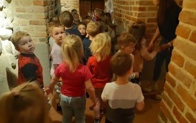 Dzieci zwiedzają zabytkowe piwnice Muzeum.