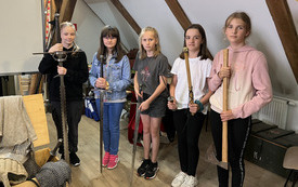 Dziewczynki z klasy IV prezentują broń podczas warsztat&oacute;w rycerskich na zamku w Olsztynie