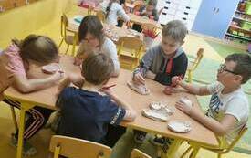 Uczniowie kl. 1-3 szkliwią gliniane miseczki.