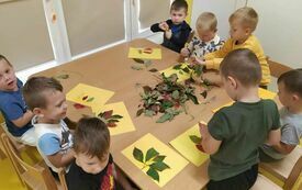 Chłopcy tworzą jesienne prace plastyczne.