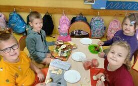 Wiktoria, Sandra, Filip, Sebastian wykonują szaszłyki owocowe