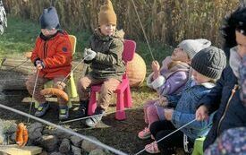 Przedszkolaki pieką kiełbaski.