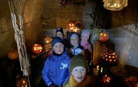Kuba, Szymon, Barbara, Lena i Łucja zwiedzają piwniczkę z dyniowymi lampionami