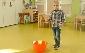 Oluś z grupy Krasnale rzuca monetą.