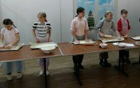 Uczestnicy warsztat&oacute;w rozwałkowują ciasto