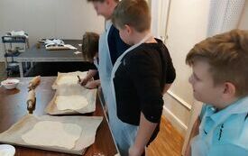 Chłopcy z kl. 5 podpisują swoje tace z pizzą