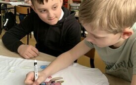 3 Chłopcy z klasy II wykonują kolorowe koszulki dla dziewczynek