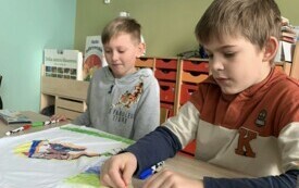 2 Chłopcy z klasy II wykonują kolorowe koszulki dla dziewczynek