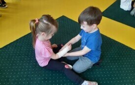 Wojtuś bandażuje rękę Biance.