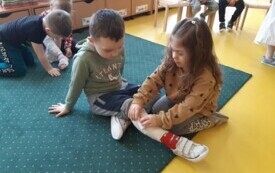 Nadia opatruje nogę Bartka.