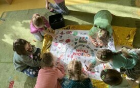 Dziewczynki z zer&oacute;wki tworzą plakat WITAJ WIOSNO.