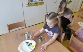 Marcelinka maluje tekturowy wazon.