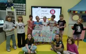 Dziewczynki prezentują własnoręcznie wykonany plakat pt. NIE PAL PRZY MNIE, PROSZĘ !