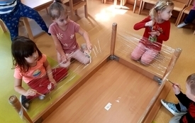 Dziewczynki z grupy Żabek malują obrazy na folii.